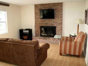 ein Wohnzimmer mit Couch und Kamin in der Unterkunft Family-Friendly Cabin Retreat on the Shores of Pokegama Lake, Minnesota in Grand Rapids