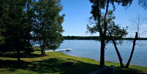 a boat in the middle of a lake with trees at Family-Friendly Cabin Retreat on the Shores of Pokegama Lake, Minnesota in Grand Rapids +10 photos