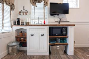 a kitchen with a counter with a microwave and a tv at Rustic and Romantic Cabin with Breakfast Included near Royse City, Texas in Quinlan