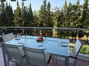 una mesa con sillas y un bol de fruta en el balcón en Beautiful F2 pool in Islette du Riou, en Mandelieu-la-Napoule