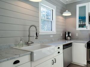 a white kitchen with a sink and a window at Modern Luxury Farmhouse with a Jacuzzi Tub near Woodstock, Vermont in Bridgewater