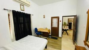 a bedroom with a bed and a desk and a table at Green Island homestay in Kadalundi +20 photos