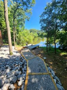 a stone path with a picnic table and a lake at Gorgeous Secluded Wooden Cabin in Carbondale, Illinois in Etherton