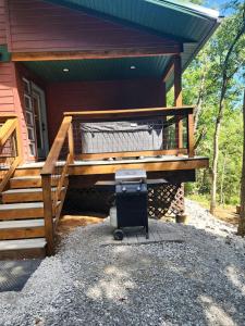 a barbecue grill sitting under a porch of a house at Gorgeous Secluded Wooden Cabin in Carbondale, Illinois in Etherton +20 photos