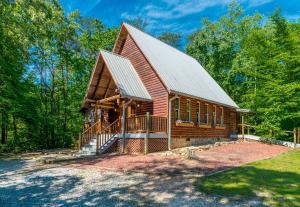 a large log cabin with a porch and a gambrel roof at Lovely Cabin with Hot-tub and Fireplace in Cleveland, Georgia in Kinseytown