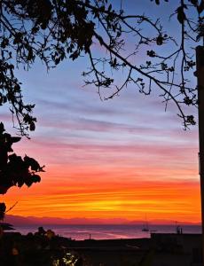 a sunset over the ocean with a boat in the distance at WINDOW on the SUNSET in Cefalù