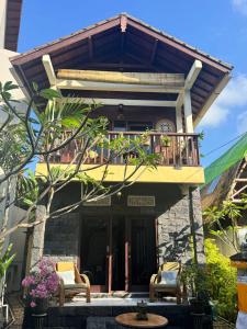 Casa con balcón con sillas y mesa. en Villa Harmoni Candidasa beach, en Candidasa