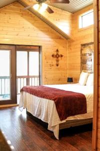a bedroom with a bed in a wooden cabin at Pipe Creek Cabin Rental for Glamping Getaways near Austin, Texas in Pipe Creek