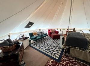 a living room in a tent with a bed and chairs at Magical Glamping Tent in the Woods near Stone Mountain State Park, North Carolina in Traphill