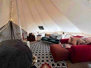 a living room with a tent with a red couch at Magical Glamping Tent in the Woods near Stone Mountain State Park, North Carolina in Traphill +4 photos