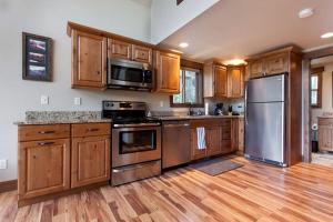 a kitchen with stainless steel appliances and wooden cabinets at Charming Mountain Cabin for a Family Getaway near Lake McDonald, Montana in West Glacier