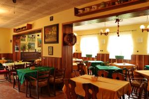a restaurant with tables and chairs with green tables at Pension Skalka in Doksy