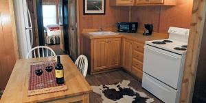 a kitchen with a table with a bottle of wine at Secluded Cabin Perfect for a Romantic Getaway in Austin County, Texas in Cat Spring