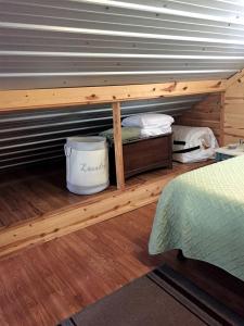 une chambre avec un lit superposé avec un seau sur une étagère dans l'établissement Secluded Cabin on Organic Working Farm in the Ozarks of Northern Arkansas, à Maumee