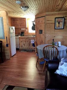 une cuisine et une salle à manger avec une table et un réfrigérateur dans l'établissement Secluded Cabin on Organic Working Farm in the Ozarks of Northern Arkansas, à Maumee
