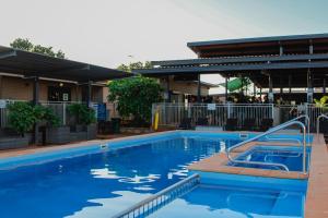 a blue swimming pool with a slide in it at Oasis Newman in Newman