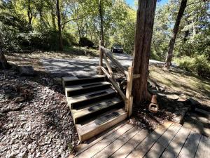 a wooden staircase sitting next to a tree at Romantic Ozarks Cabin Rental in Secluded Woodland near Branson, Missouri in Hollister +4 photos