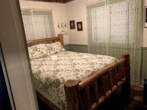 a bedroom with a wooden bed with a comforter at Secluded Forest Cabin in Rhododendron near Mt Hood Village in Oregon in Brightwood