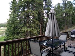 a patio table with an umbrella on a deck at Impressive Cabin Rental with Views of Pike National Forest near Colorado Springs, Colorado in Westcreek