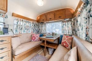 a living room with a couch and a table at Fabulous Cozy Airstream Perfect for a Small Family Unique Escape in Texas in Spicewood