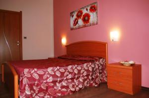 ein Schlafzimmer mit einem Bett, einer Kommode und einem Bild in der Unterkunft Un Letto a Casteddu in Cagliari