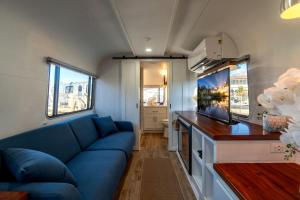 a living room with a blue couch in a caravan at Wagon Circle Unit in Prescott, AZ in Prescott +27 photos