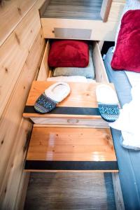 a wooden drawer in a bedroom with red pillows at Snug and Cozy Tiny House Rental near Fairbanks for Glamping in Alaska in Chena River Seaplane Base +2 photos