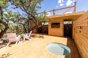 a wooden deck with chairs and a house at Cozy Yurt with Hot Tub Surrounded by Nature in Dripping Springs, Texas in Hammetts Crossing