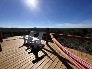 a deck with two chairs and a hammock on it at Cozy Yurt with Hot Tub Surrounded by Nature in Dripping Springs, Texas in Hammetts Crossing