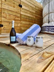 a bottle of wine and two candles on a wooden deck at Cozy Yurt with Hot Tub Surrounded by Nature in Dripping Springs, Texas in Hammetts Crossing