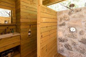 a wooden bathroom with a stone wall at Cozy Yurt with Hot Tub Surrounded by Nature in Dripping Springs, Texas in Hammetts Crossing +15 photos