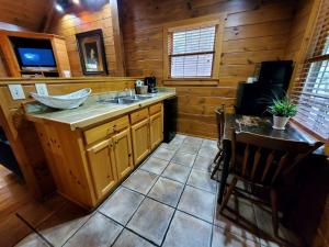 a kitchen with a sink and a table in a cabin at Charming Riverside Cabin Sanctuary Near New River, Virginia in Galax