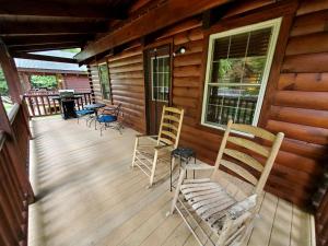 a deck with chairs and a grill on a cabin at Charming Riverside Cabin Sanctuary Near New River, Virginia in Galax