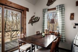 a dining room with a wooden table and a window at Lustrous Lakefront Cabin Oasis near Lake Ferndale in West Virginia in Springfield