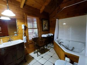 a bathroom with a tub and a sink and a toilet at Charming Riverside Cabin Sanctuary Near New River, Virginia in Galax +3 photos