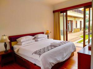 a bedroom with a large bed and a balcony at Villa Sabasanti Gianyar in Keramas +82 photos