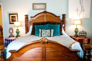 - une chambre avec un grand lit en bois et des oreillers bleus dans l'établissement Pet Friendly Breathtaking Cottage with Hot-tub in Rainbow, California, à Rainbow