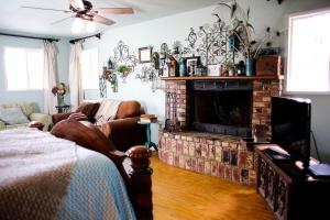 un salon avec une cheminée et un canapé dans l'établissement Pet Friendly Breathtaking Cottage with Hot-tub in Rainbow, California, à Rainbow 17 autres photos