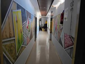 a hallway with many paintings on the walls at Hotel O The KG Meridian in Ambāsamudram