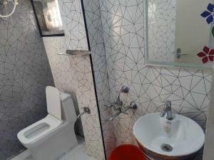 un baño con inodoro y lavabo en Hotel O The KG Meridian, en Ambāsamudram