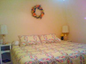 a bedroom with a bed with a wreath on the wall at Historic Vacation Rental on Acres of Farmland near Aloha State Park, Michigan in Alverno