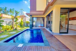 a swimming pool in front of a house at Tutde Guest House in Bringkit
