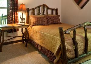 una camera da letto con un letto e un tavolo con una lampada di Family-Friendly Cabin Rental for Six on Nantahala Mountain with White Water Rafting in North Carolina a Aquone