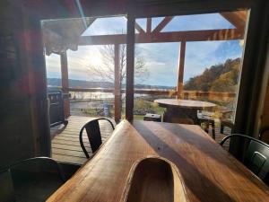 DeersvilleにあるLuminous Cabin with Hot-Tub, BBQ and Deck in Ohioの大きな窓のあるデッキの上の木製のテーブル