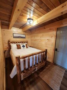 DeersvilleにあるLuminous Cabin with Hot-Tub, BBQ and Deck in Ohioの丸太小屋のベッドのある寝室