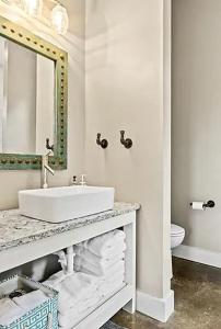 une salle de bain blanche avec un lavabo et un miroir dans l'établissement Wonderful Open-Plan Cottage for a Fantastic Family Retreat to Texas Hill Country near Dripping Springs, Texas, à Hammetts Crossing 1 autre photo