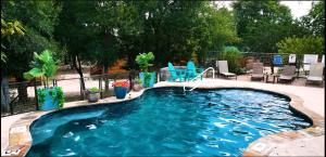 a swimming pool in a yard with chairs in it at Lovely Log Cabin Rental for Four near San Antonio Texas in Pipe Creek