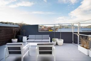 a patio with a couch and chairs on a balcony at Entire 4 Room Boutique Hotel - Central Dunedin in Dunedin