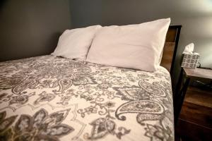a bed with a blanket and a pillow on it at Serene Loft Cabin with Outdoor Grill and Fire Pit in Creal Springs, Illinois in Sunset Harbor
