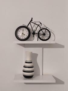 a shelf with a bike and a clock and a vase at Urban Cocoon, Nice & Easy in Athens